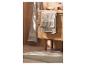 Intérieur de salle de bain: meuble-lavabo en bois clair, serviettes grises et tapis de bain clair.