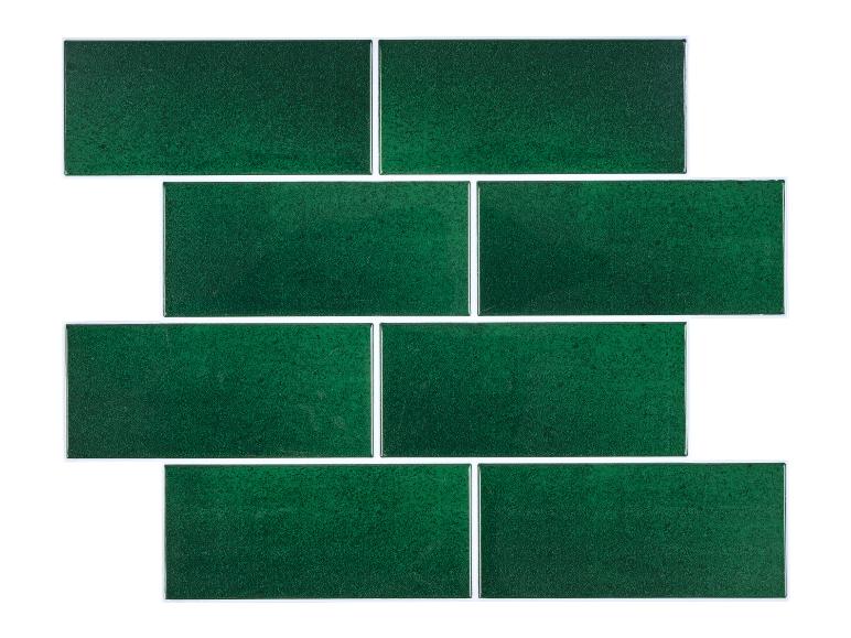 Carreaux de métro verts texturés disposés en quinconce sur un fond blanc.