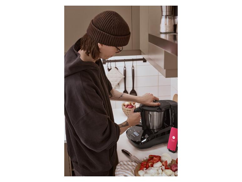 Personne préparant un repas avec le robot de cuisine intelligent Monsieur Cuisine et des légumes frais.