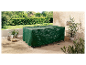 Une housse de mobilier vert foncé protège une table d'extérieur.