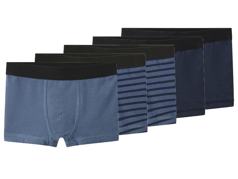 Cinq boxers pour hommes dans des tons de bleu, certains unis, d'autres rayés.