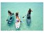 Trois personnes pratiquent le paddleboard sur une eau turquoise. Des planches de paddle Gonfiables sont visibles.
