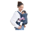Mère portant un bébé dans un porte-bébé ergonomique.