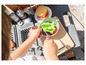 Un enfant joue avec un barbecue jouet Smoby et cuisine un hamburger.