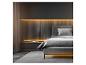 Chambre moderne avec lit gris, tête de lit en bois éclairée et rideau transparent.