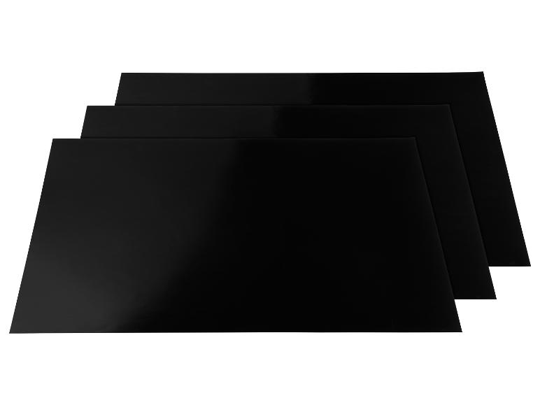 Trois feuilles de papier noir empilées en diagonale sur un fond blanc.