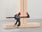 Une pince noire Parkside utilisée pour serrer des planches de bois.