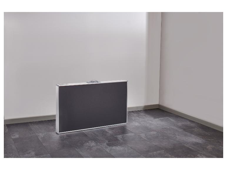 Table de camping pliable dans un coin de pièce avec sol sombre