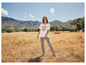 Une femme portant un t-shirt avec l'inscription 'Sun and Flowers' et un pantalon à fleurs.