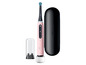 Une brosse à dents électrique Oral-B iO rose avec station de charge et étui.