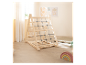 Structure d'escalade en bois pour enfants avec filet de cordes, à côté de jouets pour bébés.