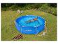 Homme se relaxant dans une piscine hors sol hexagonale bleue dans un jardin avec deux chaises de plage.