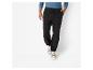 Un homme portant un pantalon noir avec un cordon de serrage et des baskets beiges.