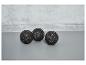 Trois balles de massage noires sur un fond gris.