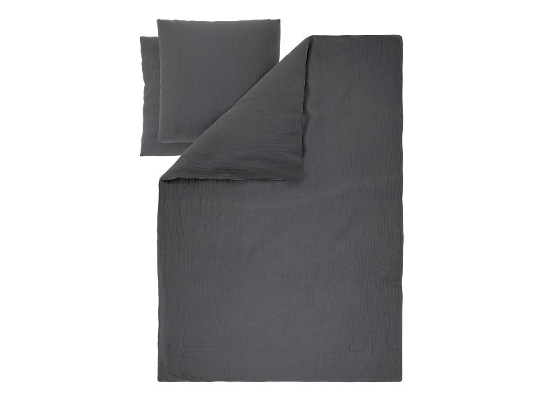 Parure de lit en mousseline gris foncé avec deux oreillers et une couette.
