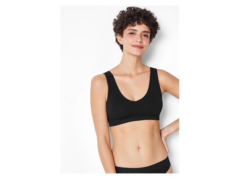 Une femme porte un soutien-gorge et une culotte noirs sans couture.