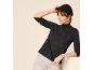 Femme en sous-pull col roulé gris foncé, bonnet noir et jean clair.