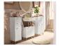 Meubles de salle de bain blancs avec plateaux et pieds en bois, miroir rond, lavabo et accessoires.