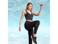 Femme en soutien-gorge de sport noir et leggings noirs avec des baskets noires.