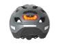 Un casque de vélo gris avec un feu arrière rouge.