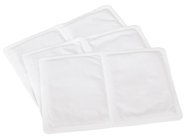 Quatre coussins chauffants blancs ou chauffe-mains, disposés en pile superposée.
