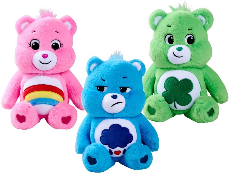 Trois peluches Bisounours : rose, bleue et verte, avec des insignes distinctifs sur le ventre.