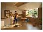 Jeune couple dans la cuisine avec robot aspirateur, coin repas et plantes.