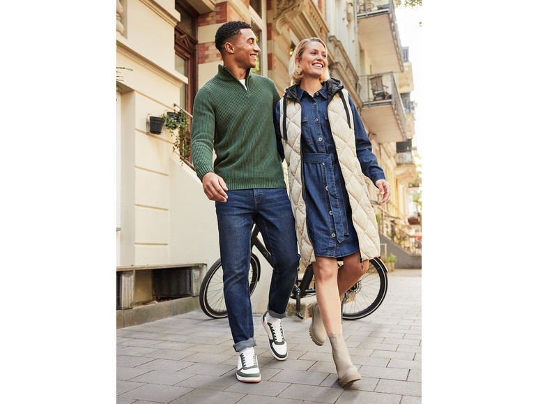 Un homme et une femme marchent dans la rue avec un pull et une robe en jean.