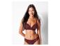 Une femme porte un soutien-gorge et une culotte assortis de couleur bordeaux avec de la dentelle.