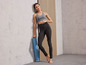 Femme en tenue de sport avec un tapis de yoga