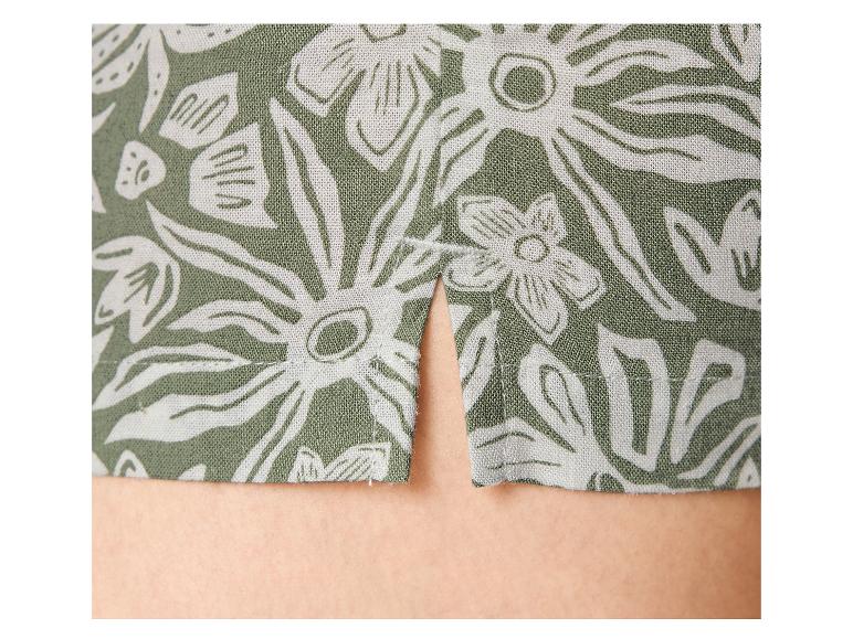 Tissu vert à motif floral blanc avec une fente à l'ourlet.