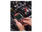 Homme testant une batterie de voiture avec un testeur Ultimate Speed.