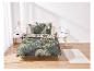 Un lit avec des draps tropicaux à feuilles vertes.