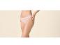 Femme en culotte rose clair, les mains sur les hanches.