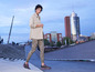 Une femme porte une chemise beige, un legging camouflage et des chaussures Salomon.