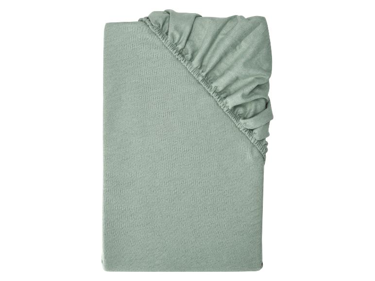 Drap-housse vert clair plié avec élastique