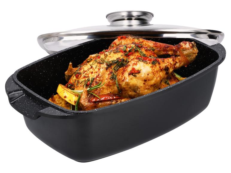 Poulet rôti aux herbes et citron dans une rôtissoire noire avec couvercle en verre