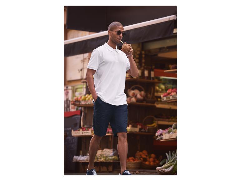 Polo blanc, short bleu marine et noix de coco : style estival décontracté.