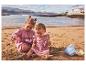 Deux filles jouent avec des jouets de plage dans le sable.