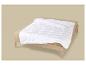 Couette blanche sur un lit en bois avec des draps beiges