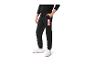 Pantalon de survêtement noir avec logo Marvel et baskets blanches.