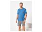 Homme souriant en t-shirt bleu et short gris.