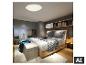 Chambre moderne avec un grand lit, un plafonnier et un coin salon près de la fenêtre.