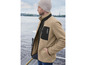Un homme porte une veste en polaire beige avec des accents noirs de la marque 'Pikes Peak'.