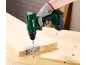Main gantée utilisant une perceuse sans fil pour visser une charnière sur une planche en bois.
