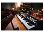 Un clavier noir avec des touches blanches sur une table en bois à Noël.
