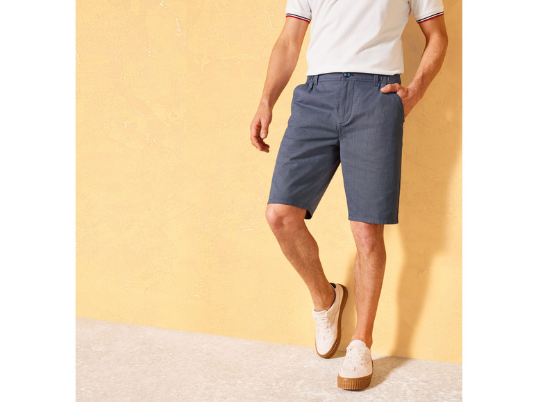 Homme portant un short bleu et des baskets blanches