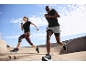 Deux personnes courent en extérieur en tenue de sport noire, incluant t-shirts, shorts et leggings.
