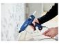 Pistolet à colle LIVARNO® »EG320« utilisé pour fixer une moulure au mur.