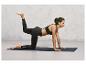 Une femme fait un exercice de yoga sur un tapis noir.